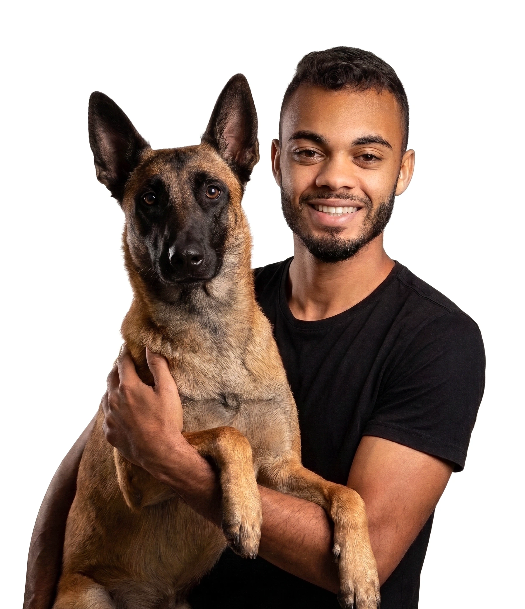 Guilherme Landim sorrindo, de camiseta preta, segurando um pastor belga no colo em frente a um fundo branco